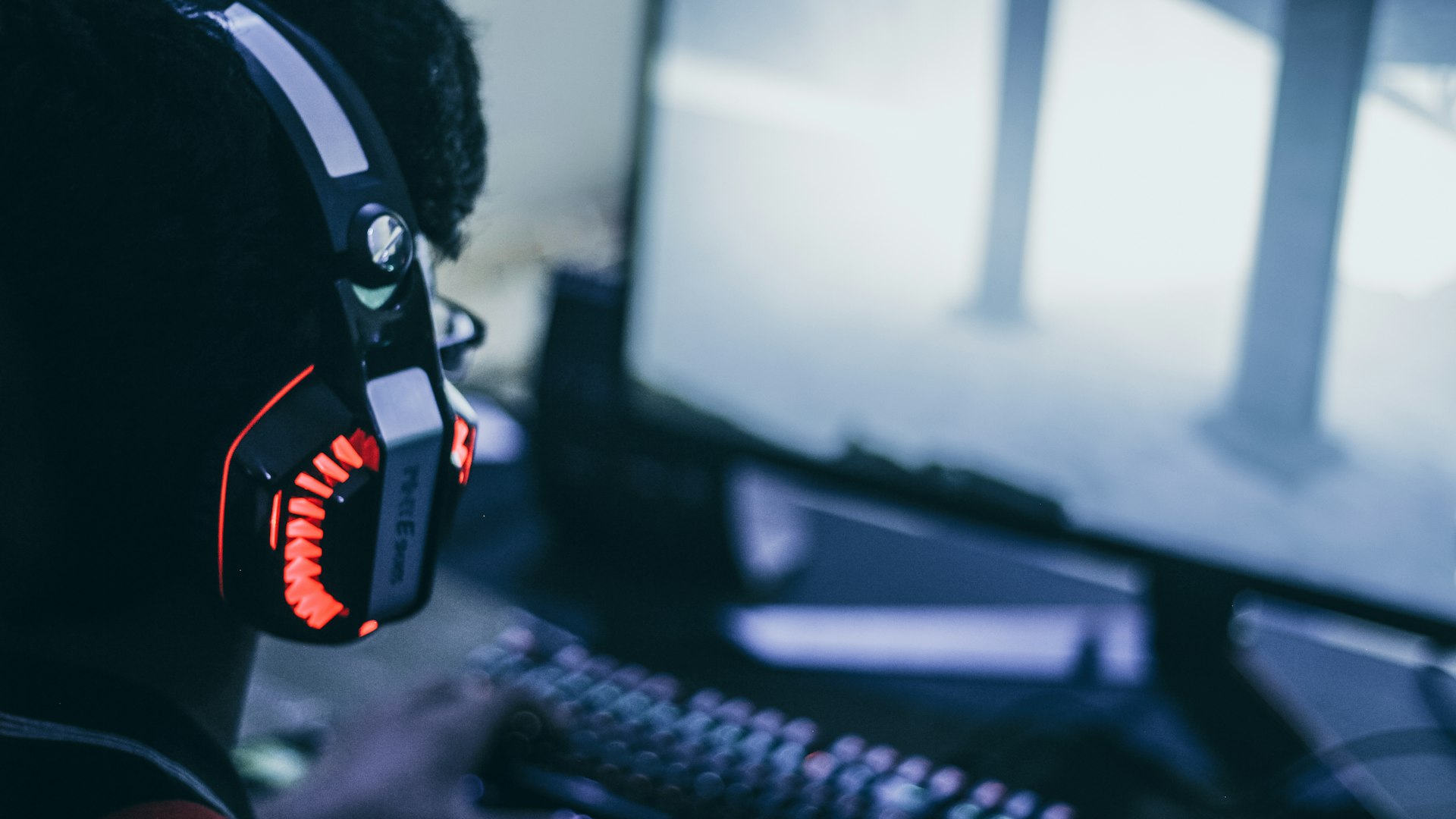 Raiders gathered around glowing screens in a dark LAN room